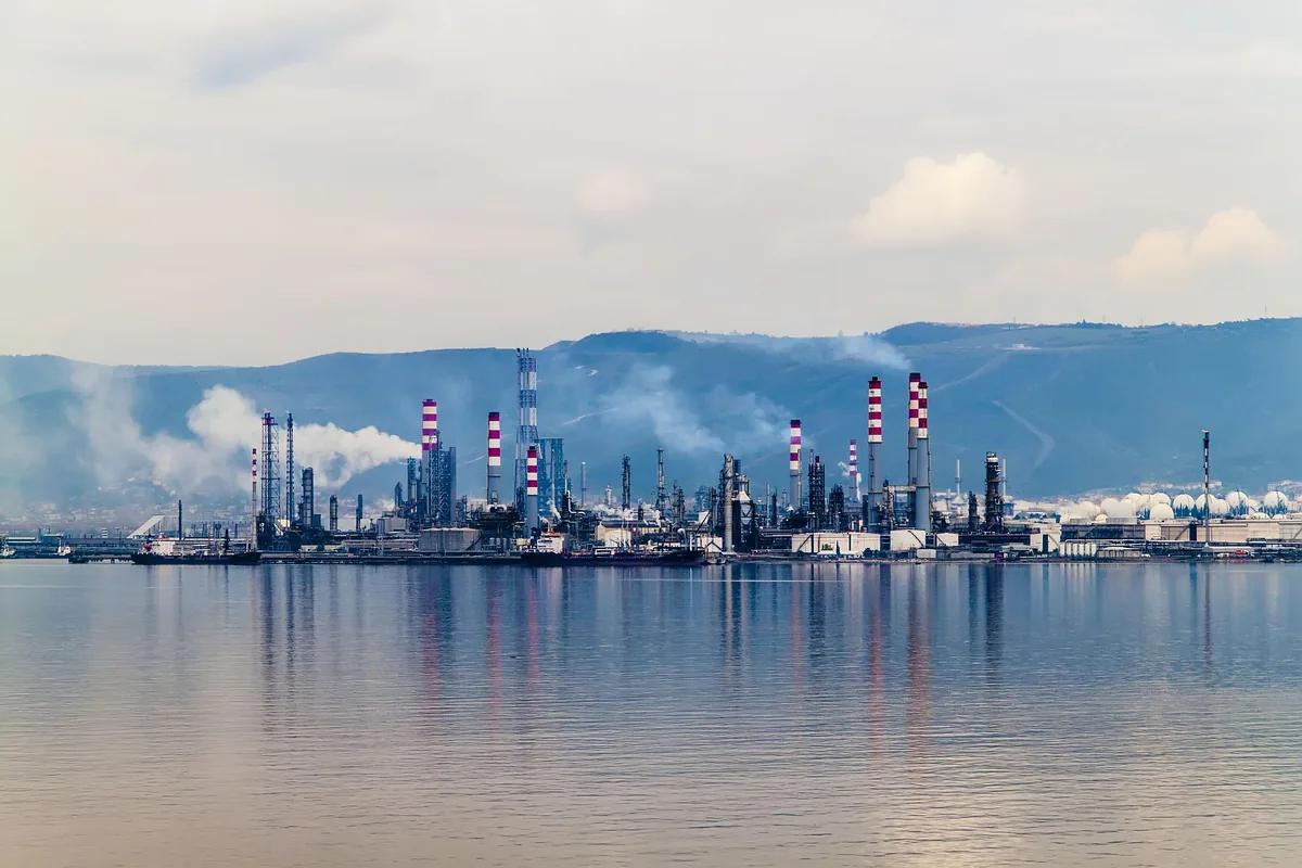 Coastal oil and gas refinery at dusk, seen across the water