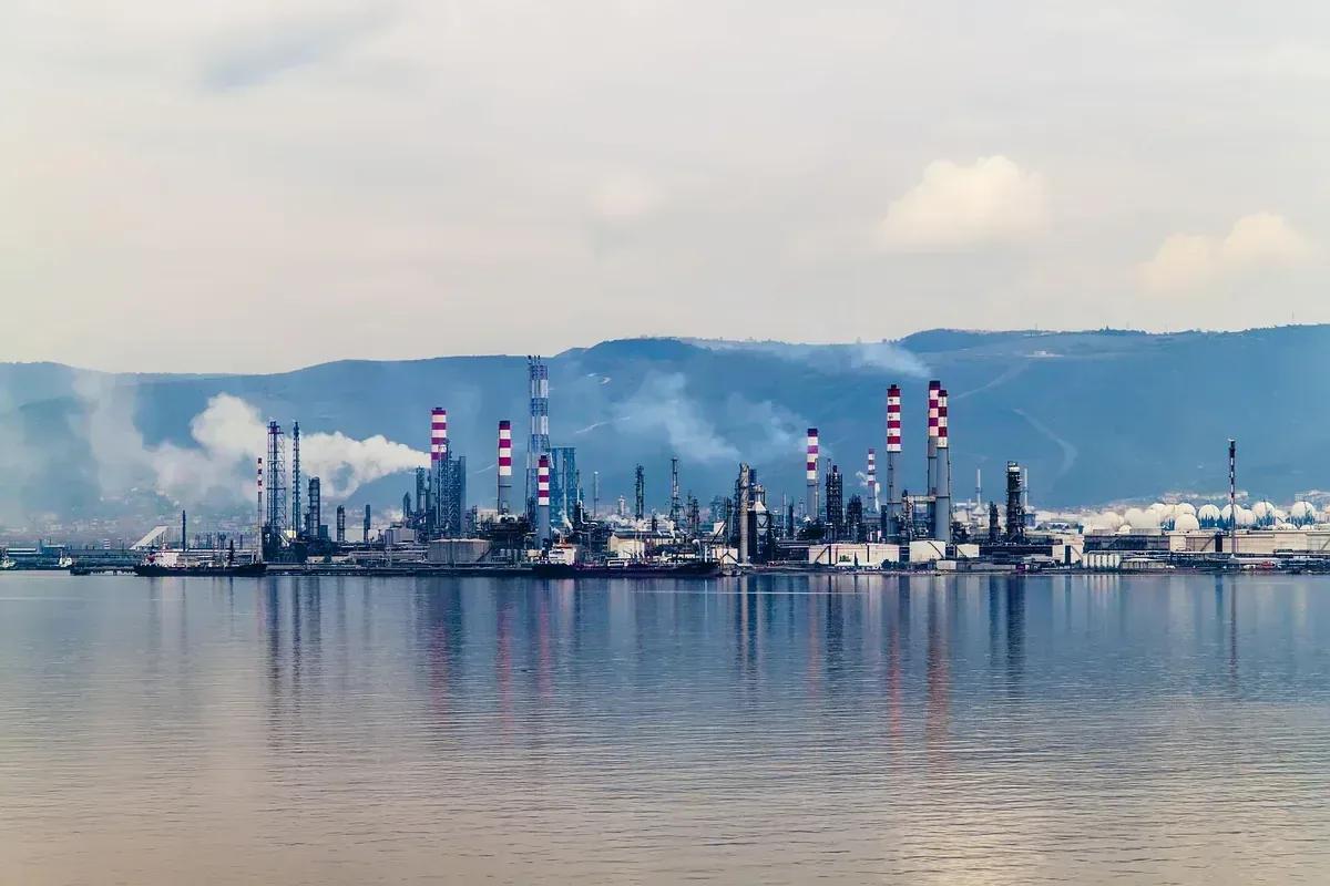 Coastal oil and gas refinery at dusk, seen across the water