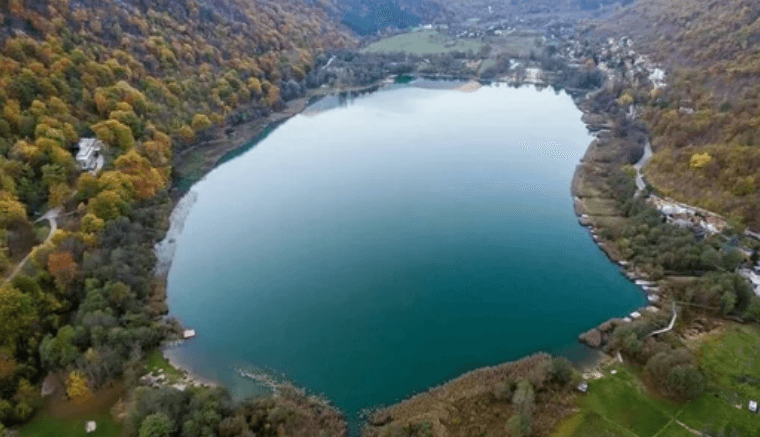 Aerial view of a lake surrounded by autumn woodland, representing a data lake