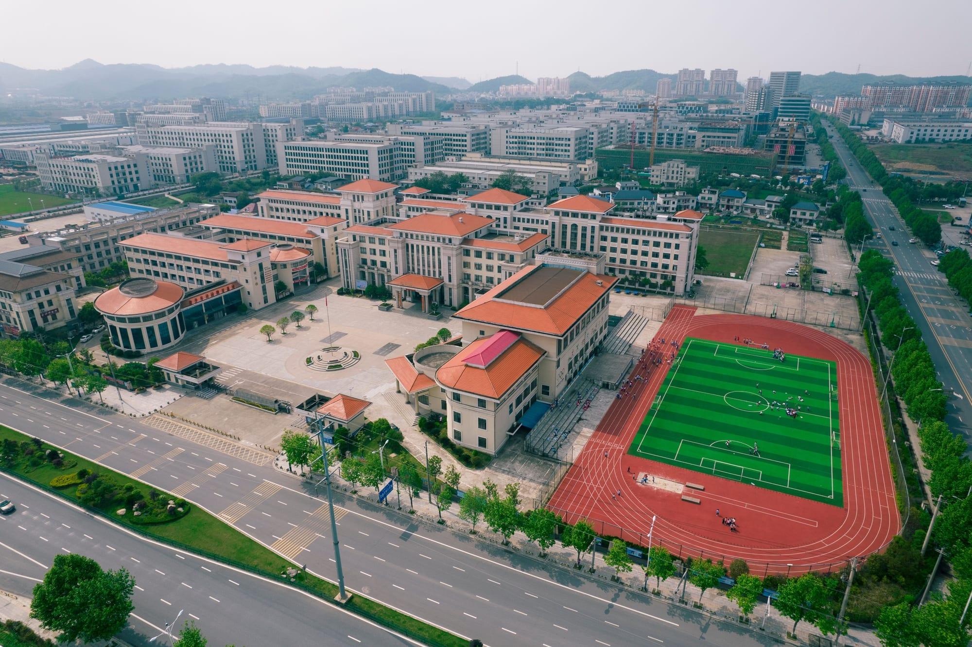Aerial view of a modern school campus with sports field
