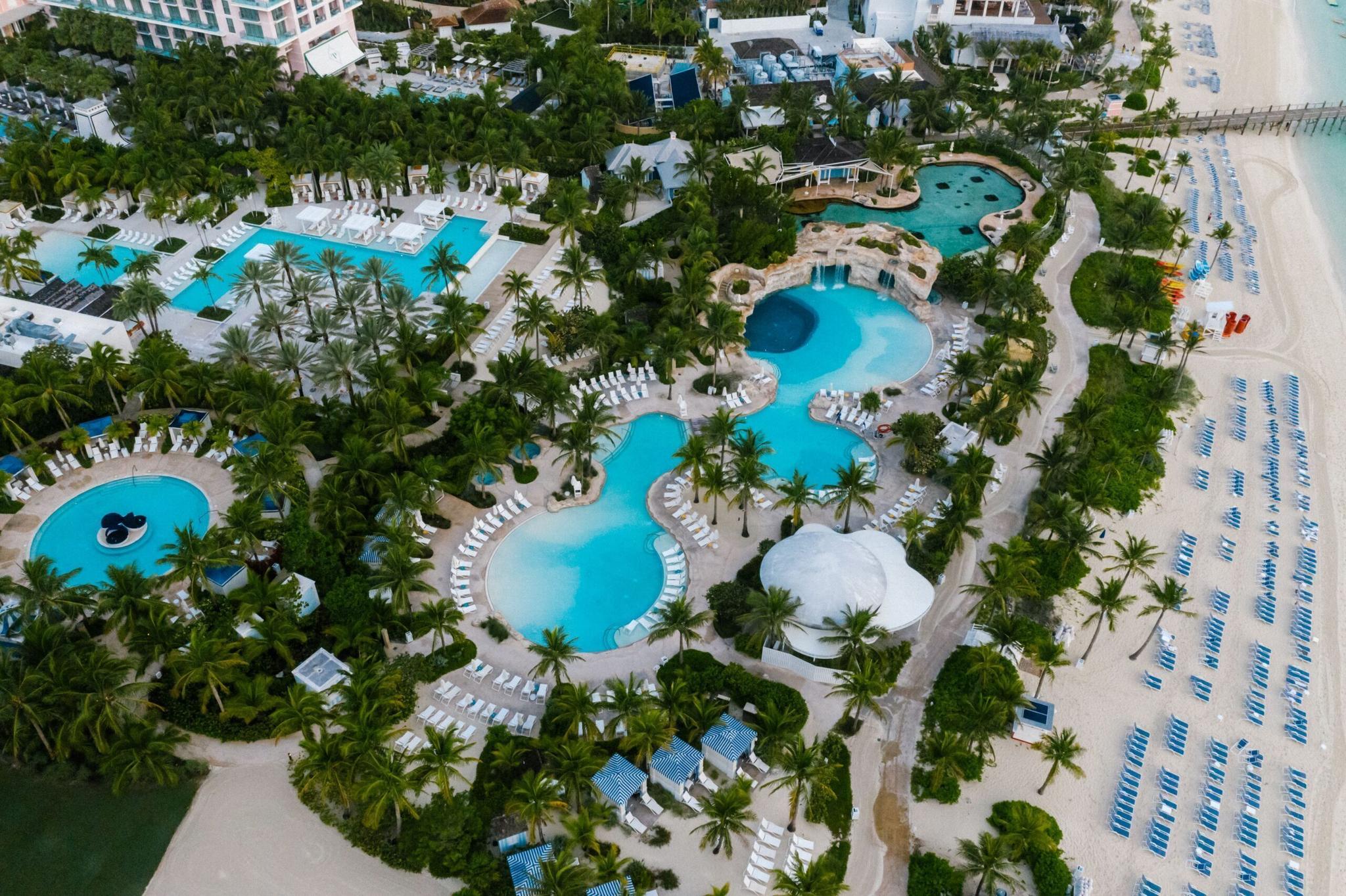 Toàn cảnh khu hồ bơi của một resort ven biển, tượng trưng cho chuỗi khách sạn nhiều cơ sở
